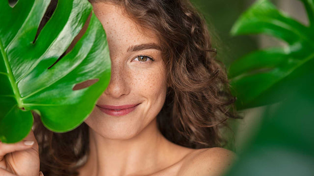 zoom-rosto-tronco-mulher-jovem-segurando-planta-fundo-plantas