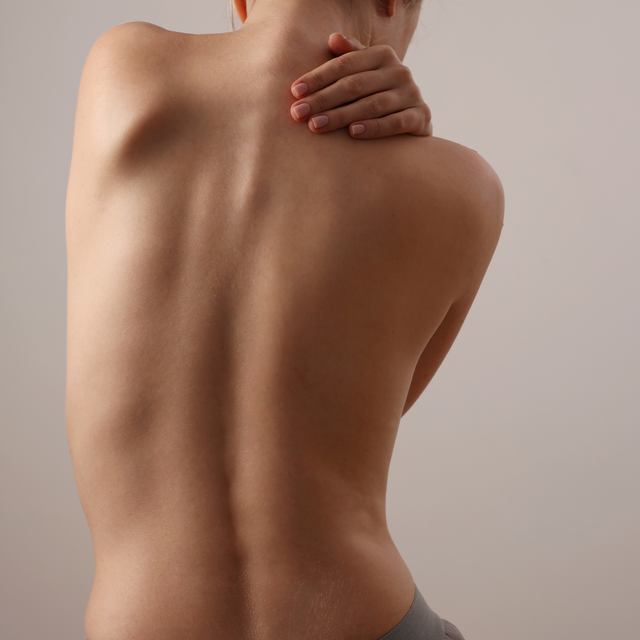 imagem costas mulher sobre espinha e tratamento